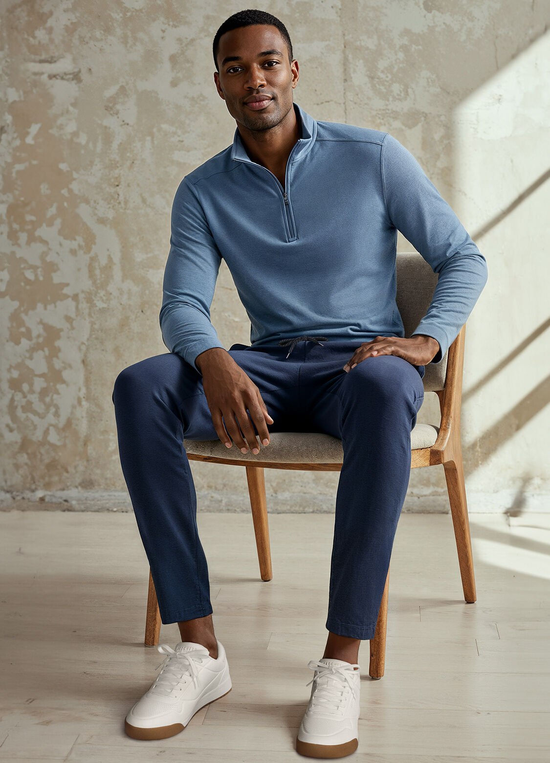 man in skechers on chair